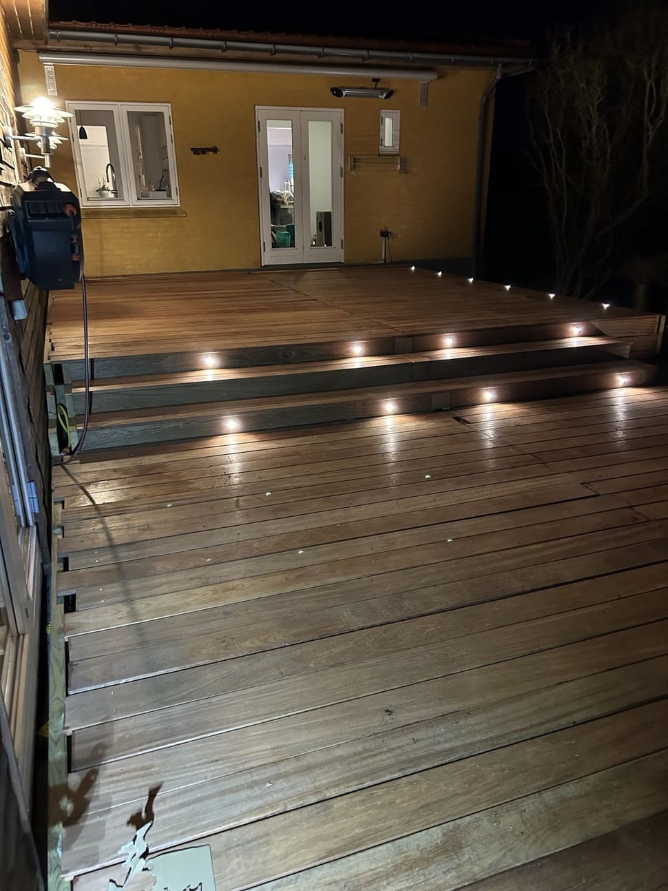 Trædæk med indbyggede LED-spots tændt i skumring