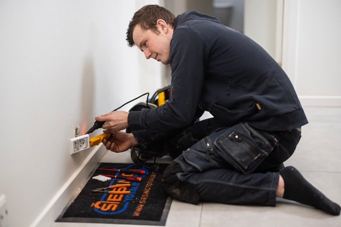 Elektriker fra Siesing Totalbyg måler på en stikkontakt under el-renovering