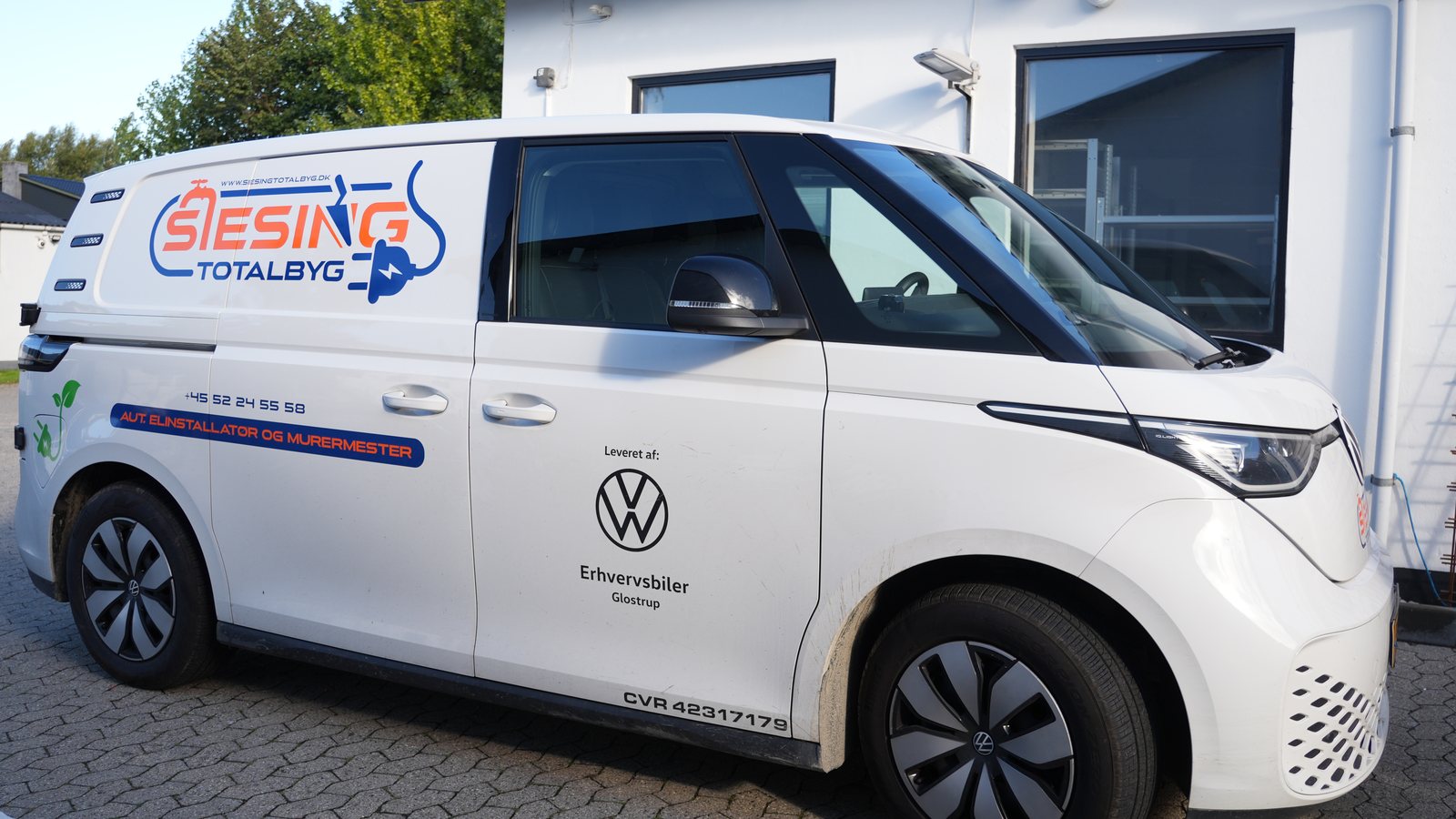 Siesing Totalbygs elektriske varevogn med logo og elstik-ikon