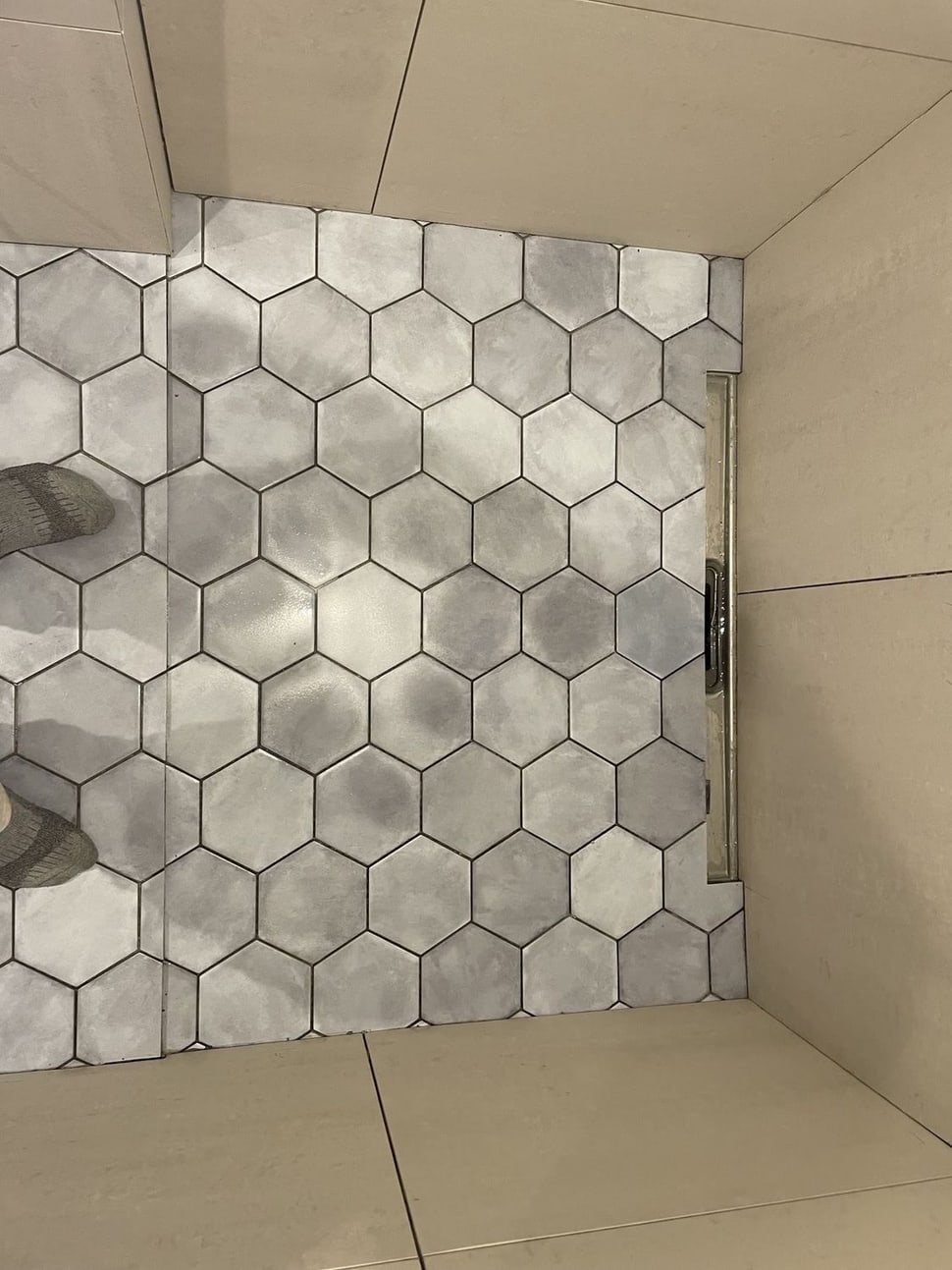 Grå hexagon-fliser på brusevæg og gulv
