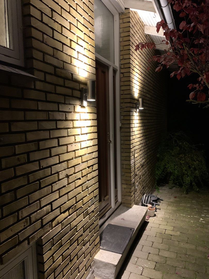 Tændte udendørs væglamper ved en indgang, sikkert el-arbejde fra Siesing Totalbyg